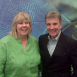 Private investigator event attendees smiling together in front of a colorful backdrop