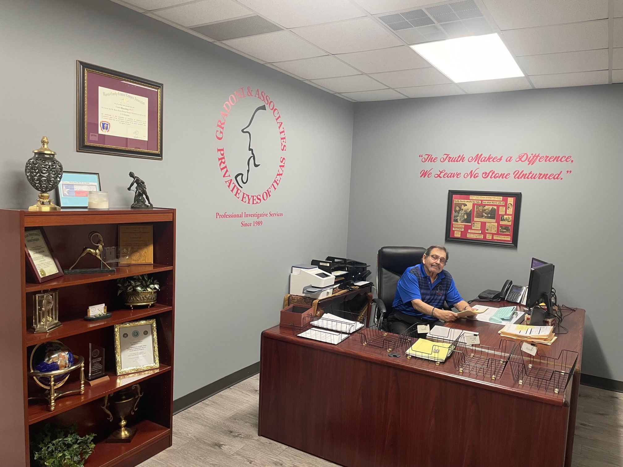 Private investigator in houston seated in office with awards and Gradoni & Associates branding